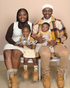 a family sitting on a white bench posing for a photo with the word love spelled in cursive letters