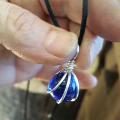 "These are lovely 14 - 15mm (1/2 - 5/8\") in diameter round cobalt blue glass marbles that we cleverly wire wrapped with 18 gauge sterling silver wire. The entire pendant measures just about 1 1/8\" (2.8cm) from the very top of the bail to the bottom of the pendant. You can add a 30\" black satin cord with NO clasp that can be tied to any length you want for $.50. You can also choose a 16 or 18\" black cord with a clasp for an extra $8.50 or a 16 or 18\" sterling silver 1.2mm curb chain with spr Hand-wrapped Blue Round Jewelry, Blue Wire Wrapped Round Bead Jewelry, Blue Wire Wrapped Round Necklace, Necklace Sapphire, Marble Necklace, Marble Jewelry, Sterling Silver Wire Wrap, Makeup Makeover, Glass Marbles