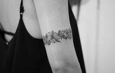 a woman's arm with a flower tattoo on the left side of her arm