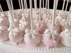 there are many pink and white candies on the plate with toothpicks in them