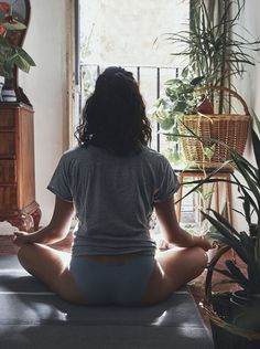 a woman sitting in the middle of a yoga pose