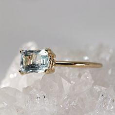 an aquamarinee ring sitting on top of crystal rocks