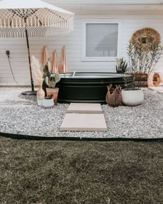 an outdoor hot tub surrounded by gravel and plants