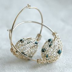 a close up of a pair of earrings on a white surface with some wire around it