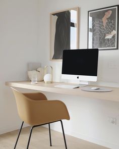 a desk with a computer, chair and pictures on the wall