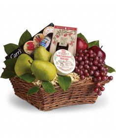 a basket filled with fruit and cheese on top of a white table next to a black background