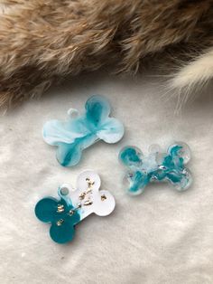 three blue and white flower shaped buttons on a fur coat, one is attached to the other