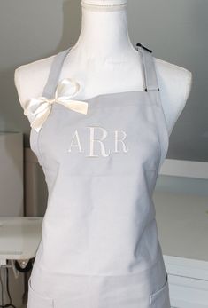 an apron with the initials arr on it and a bow at the front is sitting on a mannequin