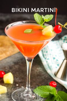 a close up of a drink in a glass on a table with fruit around it