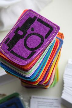 a stack of colorful felt coasters sitting on top of a white table next to each other