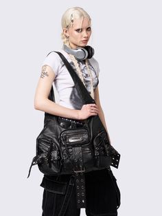 Upgrade your bag collection with Minga London's black vegan leather shoulder bag. Edgy buckle straps, multi pockets and a touch of edgy, punk, grunge, y2k aesthetic. Shop now at Minga London! Edgy Bags With Adjustable Strap For Concert, Alternative Style Concert Bag With Adjustable Strap, Edgy Shoulder Bag With Gunmetal Hardware For Travel, Grunge Bags With Adjustable Strap For Alternative Fashion, Alternative Black Shoulder Bag For Concerts, Edgy Crossbody Bag For Concerts, Edgy Leather Bags For Concerts, Alternative Fashion Bags With Hardware, Black Grunge Shoulder Bag For Concerts