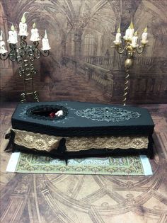 an elaborately decorated table with candles on the side and a cloth covered box in the middle