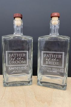 two bottles of groom's cologne sitting on top of a wooden table