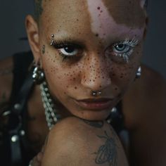 a woman with tattoos and piercings on her face