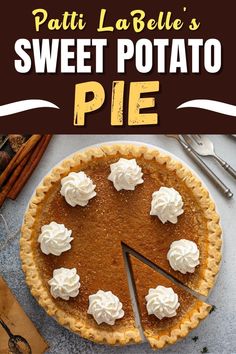 a pie sitting on top of a table next to a knife and some cinnamon sticks