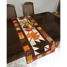 a dining room table with a quilted runner on it