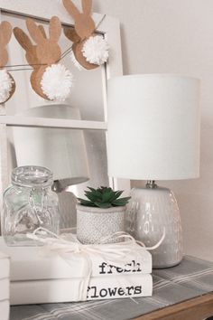 a white shelf topped with books and a lamp