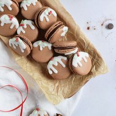 cookies decorated with icing and frosting on top of a piece of parchment paper