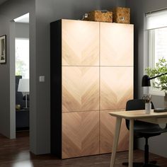 a room with a desk, chair and large wooden cabinet in the middle of it