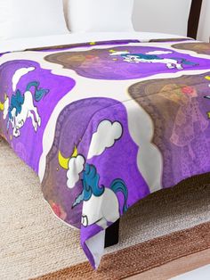 a bed with a purple and white blanket on top of it