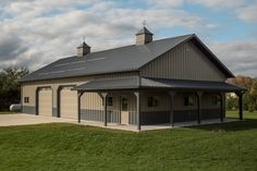 a large metal building sitting on top of a lush green field