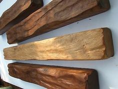 three pieces of wood sitting on top of a white wall