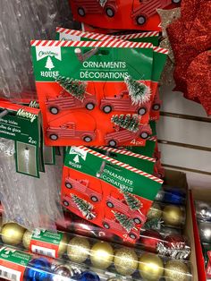 christmas ornaments are on display for sale in a store window with red and green boxes