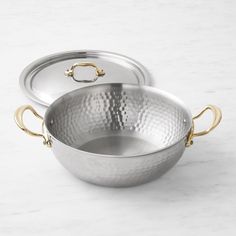 two stainless steel pans with gold handles