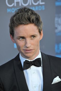 a man in a tuxedo and bow tie looking at the camera royalty images