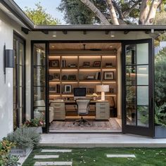 a home office in the backyard with sliding glass doors and built - in shelving