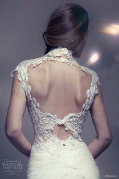 the back of a woman's wedding dress with an open neck and lace detailing