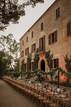 a long table with place settings in front of an old building