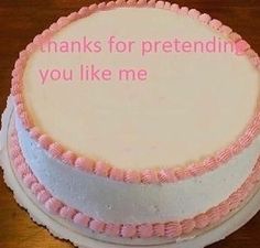 a white cake with pink icing and words on the top that says thanks for pretending you like me