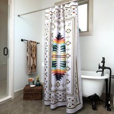 a bathroom with a bathtub, shower curtain and rug on the floor in front of it