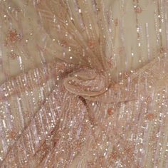 the fabric is covered with sequins and beads in gold, pink and white colors