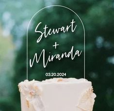 a close up of a wedding cake with a sign on it that says stewart and miranda