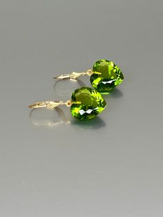 Gorgeous sparkly peridot heart earrings.The Faceted heart shape drops are flawless and have a beautiful clear green color. The drops attached to secure 14k gold-filled lever backs. The earrings are elegant and have a lux look. A truly gorgeous pair of earrings. *AAA+ Faceted peridot hearts *The dimension of stones is about: 15mm *Metal: 14k gold filled *Earrings drop length (ear wires including the stones): 32 mm/ 1.3 inch Solid gold, 14K gold-filled, sterling silver, and gemstones are my materi Elegant Green Earrings With Heart Charm, Elegant Green Heart Earrings For Gift, Elegant Gemstone Heart Drop Earrings, Heart-shaped May Birthstone Earrings For Anniversary, Heart Shaped May Birthstone Earrings For Anniversary, Heart-shaped Gemstone Earrings As Gift, Elegant Heart-shaped Gemstone Earrings, Elegant Green Heart Cut Earrings, Heart-shaped Green Jewelry With Matching Earrings