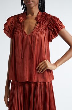 This crinkled satin tie-neck top is designed with a pleated yoke and fluttering layered-ruffle sleeves. 24" length (size 8) Ties at neck Short sleeves 100% polyester Dry clean Imported Silk Ruffle Short Sleeve Top, Silk Ruffled Short Sleeve Top, Ruffle Lace Top, Pleated Tops, Tie Neck Tops, Tie Shorts, Satin Top, Designer Clothes For Men, Ruffle Sleeves