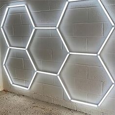 a white brick wall with hexagonal lights in the shape of honeycombs