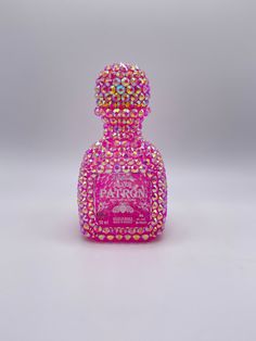 a pink bottle with lots of colorful beads on it's top and the bottom