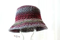 a crocheted hat is displayed on a stand