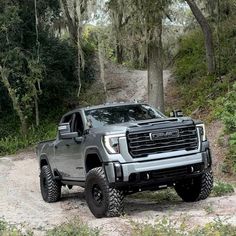 a gray truck driving down a dirt road