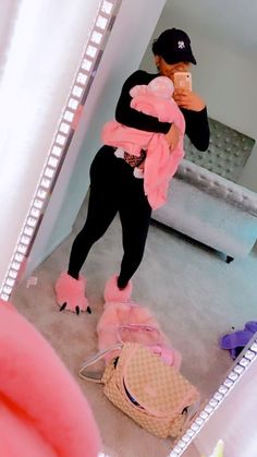 a woman taking a selfie in front of a mirror with her pink outfit on