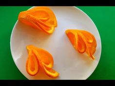 three peeled oranges are on a white plate