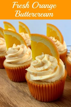 fresh orange buttercream cupcakes on a wooden table