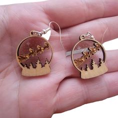 "These cute little drop earrings capture the magic of Santa's all-important trip across the sky on Christmas Eve. A sweet gift for someone or a fun and unique pair of earrings for yourself! 1/8\" birch on thin etched acrylic. Silver plated ear wires" Laser Cut Wood Earrings Christmas, Laser Cut Christmas Earrings, Acrylic Christmas Earrings, Laser Christmas Ideas, Snowglobe Earrings, Glowforge Earrings, Laser Acrylic, Christmas Snowglobe, Globe Earrings