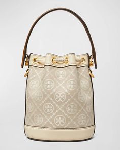 The Tory Burch T-Monogram Jacquard Mini Bucket Bag is perfectly sized for all your daily must-haves while remaining comfortably lightweight for on-the-go living. Crafted from luxe jacquard woven with the iconic 'T' print and smooth calf leather accents, it exudes effortless elegance wherever your adventures lead. With an adjustable crossbody strap allowing hands-free freedom and a handy top handle, you’ll be photo-ready for any Instagrammable moment. Spacious enough for all the essentials yet di Monogram Canvas Top Handle Bucket Bag With Dust Bag, Monogram Canvas Bucket Bag With Detachable Handle, Luxury Tan Bucket Bag With Handles, Monogram Canvas Bucket Bag With Gold-tone Hardware, Top Handle Coated Canvas Bucket Bag With Gold-tone Hardware, Top Handle Bucket Bag With Gold-tone Hardware, Tan Bucket Bag With Handles, Monogram Canvas Crossbody Bucket Bag With Removable Pouch, Formal Monogram Canvas Bucket Bag With Gold-tone Hardware