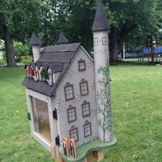 a toy house made to look like it has people on the roof and in the windows