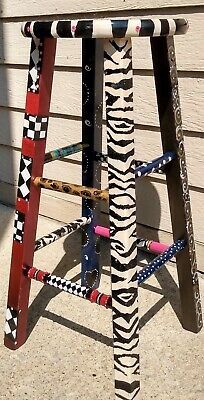 a wooden stool made to look like an animal print ladder is sitting on the side of a building