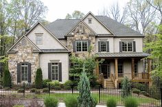 a large house with lots of windows and bushes around it's front yard area